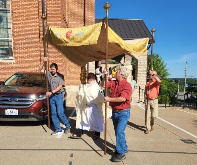 Father Tony Rinaldo, pastor of Immaculate Conception Parish in Loose Creek and St. Louis of France Parish in Bonnots Mill, carries the Most Blessed Sacrament in procession outside Immaculate Conception Church after the Vigil Mass for the Solemnity of the Most Holy Body and Blood of Christ the evening of June 18 in Loose Creek.